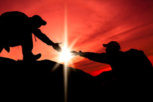 Silhouette of helping hand between a client with cancer and her mid-body energy medicine specialist